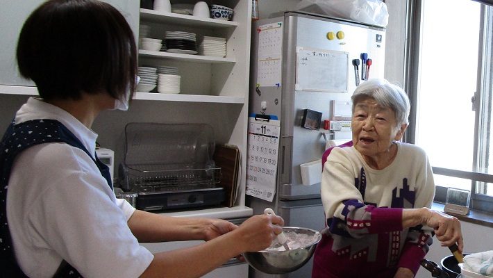 スタッフとともに料理をするご利用者さま